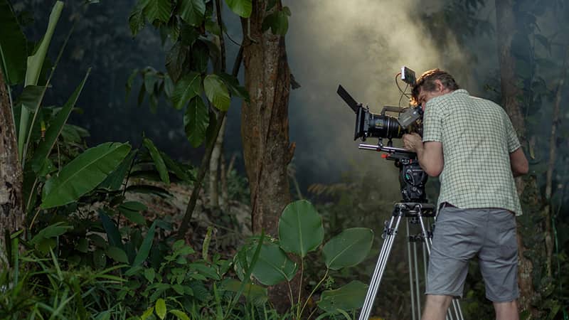 A camera operator in the jungle